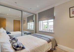 1 dormitorio con 2 camas y ventana en Pinfold Cottage, en Helmsley