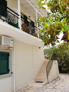 Edificio blanco con escaleras y balcón en Maresol Lefkada en Nikiana