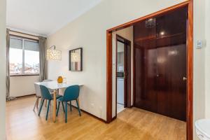 a dining room with a table and chairs and a door at Hopstays Oporto Dragão - 120 m from São Roque Park in Porto