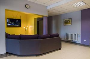 a waiting room with a couch and a tv at Haapsalu Kutsehariduskeskuse hostel in Haapsalu