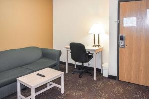 Quality Inn & Suites Brooks Louisville South في Brooks: غرفة معيشة مع أريكة ومكتب وطاولة