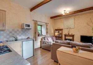 a kitchen and living room with a couch and a table at Piglet Cottage in Seamer