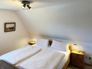 a bedroom with two beds and two night stands at Haus *Üüs Aran* Wohnung Nr. 1 in Nebel