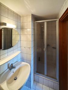 a bathroom with a sink and a shower at Haus *Üüs Aran* Wohnung Nr. 1 in Nebel