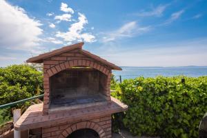 a brick oven with the ocean in the background at Mer Vue - 3 floor Private House by the Sea in Split