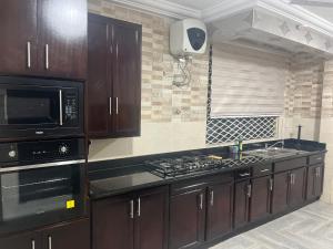 a kitchen with a microwave and a stove top oven at Boulevard Court in Ejisu