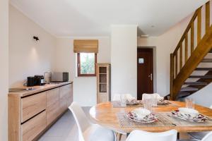 - une cuisine et une salle à manger avec une table et des chaises dans l'établissement Les Jardins de la Villa d'Olne, à Spa