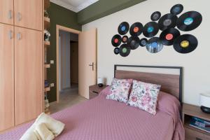 a bedroom with a bed with a bunch of records on the wall at Aurelia Apartment in Lixouri