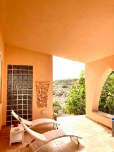 Habitación con silla y ventana en Relax e tranquillità a Cala Pisana, en Lampedusa