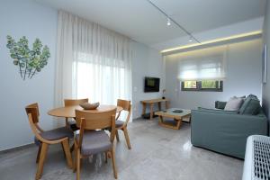 sala de estar con mesa, sillas y sofá en Carabella Residence, en Lefkada