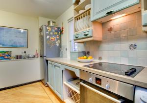 uma cozinha com armários azuis e um frigorífico em Dunes Reach 3 Dunes Court em Beadnell