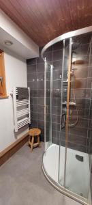 a bathroom with a shower and a wooden stool at Chalet de la Grimpette au coeur de Gérardmer in Gérardmer