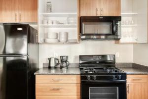 a kitchen with a black stove and a refrigerator at Woodland Hills 1BR w Gym WD Pool nr 101 LAX-683 in Los Angeles