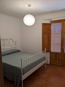 1 dormitorio con cama, lámpara y ventana en Casa Malena - Biar, en Biar