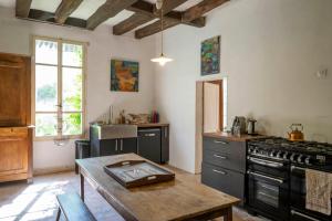 a kitchen with a stove and a table in it at Logis Cointereau in Baugé