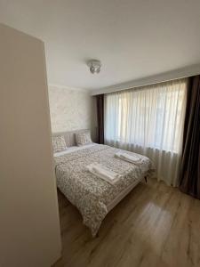 1 dormitorio con cama y ventana en Apartament 1 Lalelelor, en Năsăud