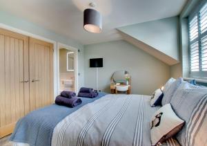 a bedroom with a large bed with purple pillows at 4 Brindles Manse in North Sunderland