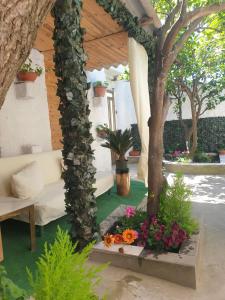una sala de estar con un sofá blanco y algunas flores en Casa vacanze con giardino e area barbecue, en Martis