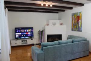 a living room with a blue couch and a flat screen tv at Villa Dina in Tar