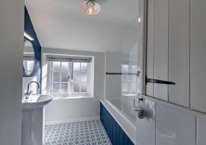 W łazience znajduje się biała wanna i umywalka. w obiekcie Glebe Farmhouse w mieście Ellingham