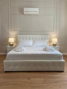 ein großes weißes Bett mit zwei Leuchten auf beiden Seiten in der Unterkunft FOUR LIONS VILLA GUESTHOUSE in Pisa