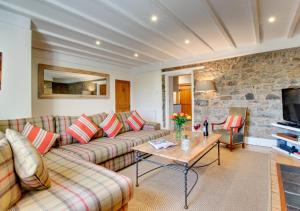 uma sala de estar com um sofá e uma mesa em Pegasus Cottage em Craster
