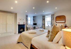 um quarto com uma cama grande e uma lareira em Pegasus Cottage em Craster