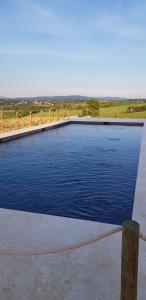 a large blue swimming pool with a fence at Al Dolce Far Niente Dimora con piscina di Design in San Biagio della Valle