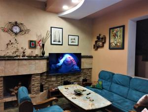 uma sala de estar com um sofá azul e uma lareira em N38 em Tbilisi