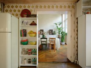 a kitchen and dining room with a table and a refrigerator at Charming and spacious house with leafy private garden close to historical center of Brussels in Brussels