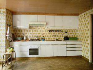 a kitchen with white cabinets and yellow tiles at Charming and spacious house with leafy private garden close to historical center of Brussels in Brussels