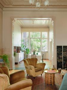 a living room with a couch and chairs and a table at Charming and spacious house with leafy private garden close to historical center of Brussels in Brussels