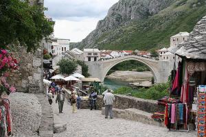 een groep mensen die door een straat lopen met een brug bij Aine Apartman - Old Bridge in Mostar