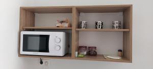 un four micro-ondes installé sur une étagère dans une cuisine dans l'établissement Helen's cozy studio 2, à Artemi