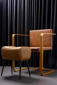 a chair with a leather seat in front of a black curtain at H34 Boutique Hotel & Spa by the sea of Nahariya in Nahariyya +56 photos