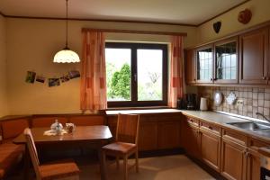 una cocina con una mesa pequeña y una ventana en NaturparkResort Haus Geigenkogel en Sankt Gallen