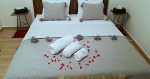 a bed with red rose petals on it at Dar Yan in Er Rachidia