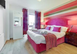 a bedroom with a large bed with a colorful wall at St Aidans Cottage in Bamburgh