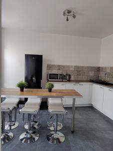 サルグミーヌにあるLe Purple, appartement de standing en hypercentreのキッチン(木製テーブル、スツール付)