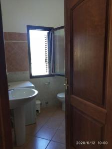 a bathroom with a sink and a toilet and a door at Acquadolce in San Teodoro