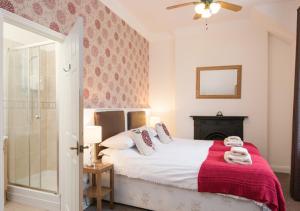 a bedroom with a bed with a red blanket at The Greenhouse in Bamburgh