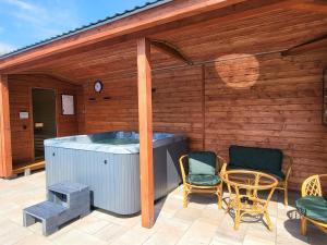 a hot tub on a patio with chairs and a table at RIVER REST - ADULTS ONLY in Świeradów-Zdrój