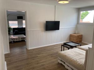 a living room with a couch and a tv on the wall at Ferienwohnung & Monteurunterkunft "Mainbogen-Blick" in Grettstadt