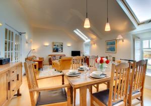 uma sala de jantar e sala de estar com mesa e cadeiras em 8 The Maltings em Bamburgh