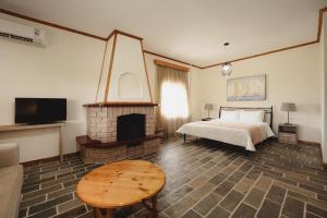 1 dormitorio con 1 cama y chimenea en Kalisun Pool House by Georgalas, en Nea Kalikratia