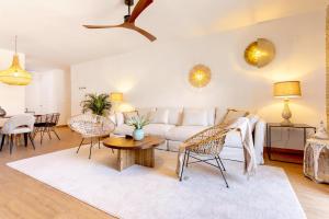 uma sala de estar com um sofá branco e cadeiras em Genteel Home Plaza Nueva Granada em Granada