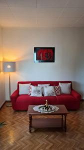 a living room with a red couch and a table at Casa degli Ulivi 19 in Faedis