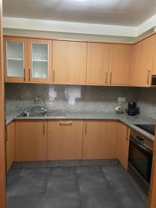 a kitchen with wooden cabinets and a sink at Vila de Cedeira in Cedeira