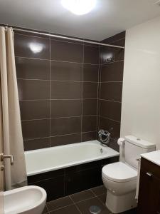 a bathroom with a white toilet and a bath tub at Vila de Cedeira in Cedeira