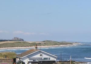 a white house with a view of a beach at No 2 The Viking in Seahouses